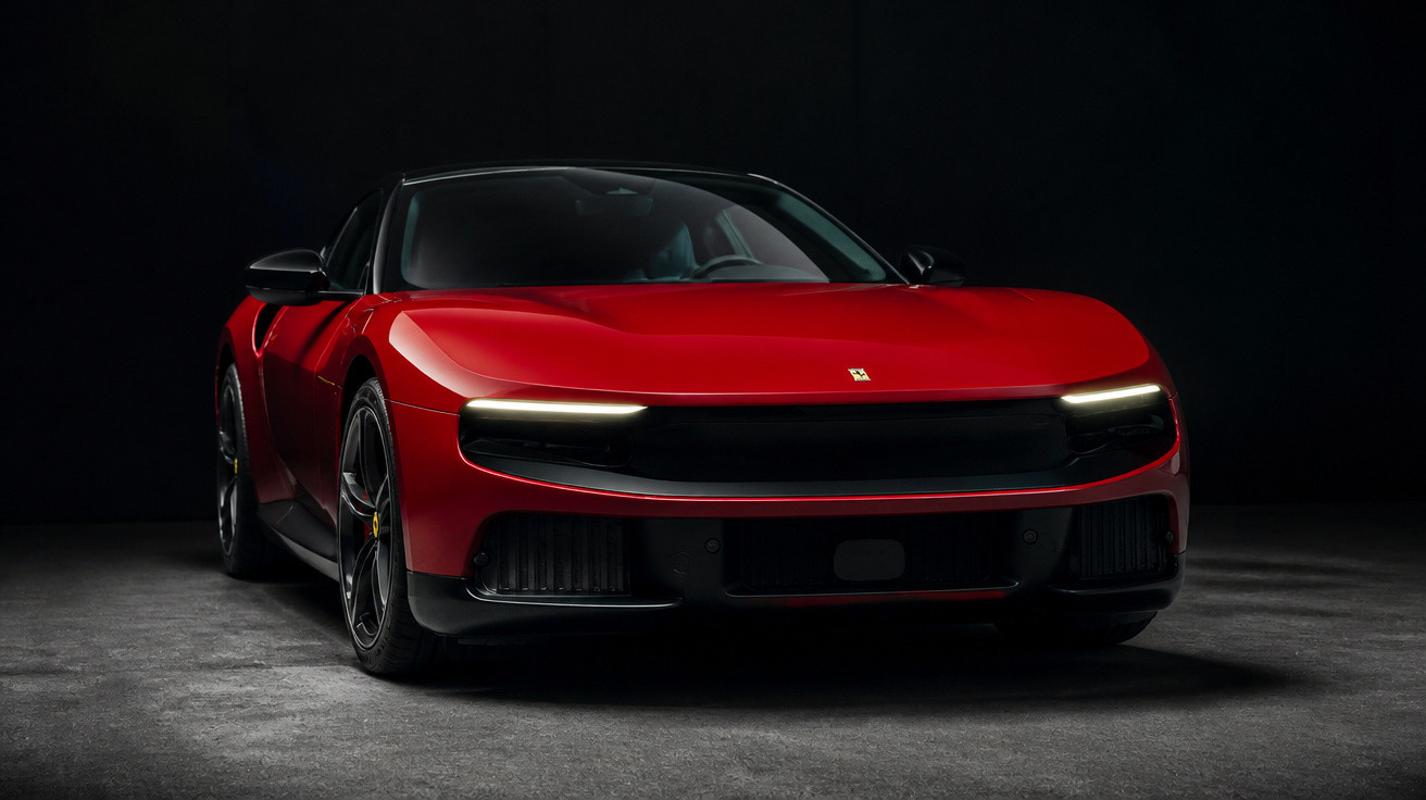 Roter Ferrari-Sportwagen mit LED-Scheinwerfern vor dunklem Hintergrund frontal abgebildet.
