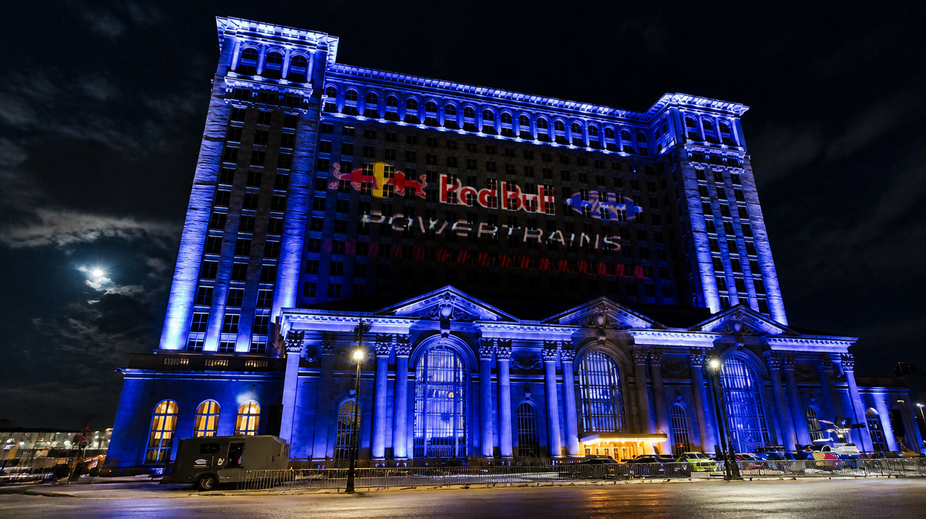 Beleuchtetes historisches Gebäude bei Nacht mit Red Bull Powertrains Logo und Vollmond im Hintergrund.