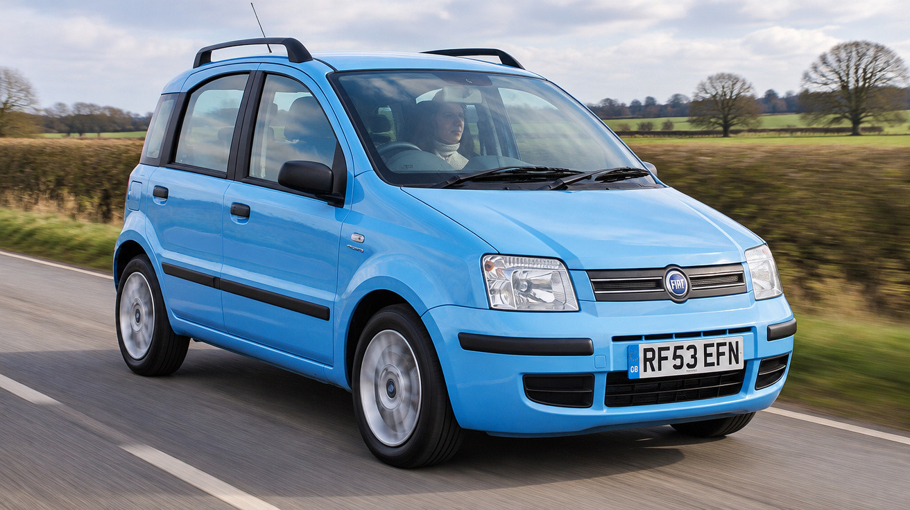 Blauer Fiat Panda fährt auf Landstraße mit Fahrerin, umgeben von Bäumen und Feldern.