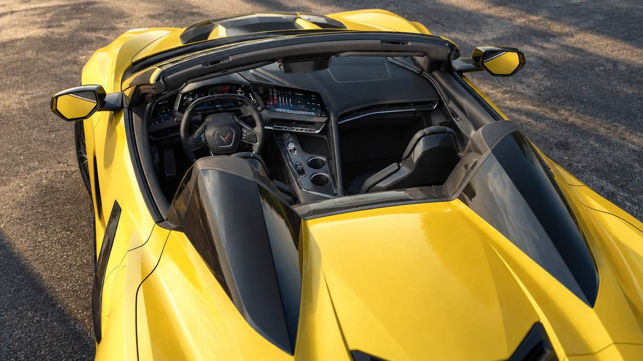 Innenansicht eines gelben Cabrio-Sportwagens mit modernem Cockpit und offenem Verdeck auf Asphaltboden.